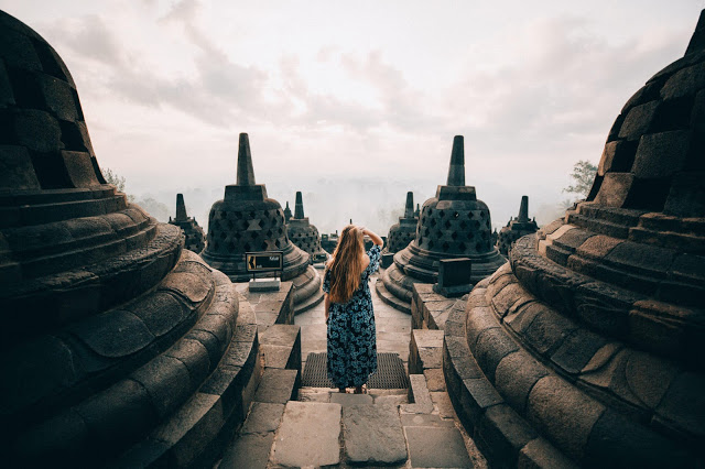Borobudur - Ngôi đền Phật giáo lớn nhất thế giới Đối lập với màn đêm huyền bí ở Prambanan là khung cảnh bình minh thơ mộng ở Borobudur - ngôi đền Phật giáo lớn nhất thế giới. Hành trình leo 100 bậc thang dốc đứng để lên tới đỉnh đền khi mặt trời chưa ló rạng, cùng chi phí khoảng 450.000 Rupiah (hơn 700.000 đồng), sẽ được đền đáp xứng đáng khi bạn đứng giữa những bức phù điêu cổ kính, tôn nghiêm, lấp lánh nắng vàng.